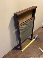 Side angle view of the antique wooden wash board showing its depth and metal scrub surface.