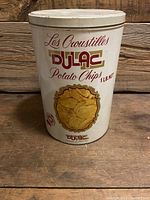 Front view of vintage Dulac potato chips tin, showing label and condition.