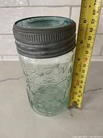 Front view of the glass jar with measuring tape showing height around 6 inches, embossed Crown Imperial logo and text visible