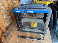 Front view of the Busy Bee surface planer showing the power cord, front handle, and manufacturer's label