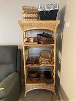 Photo of a tall bamboo bookshelf unit with six shelves holding various wood, wicker, and cloth baskets in different sizes and shapes.