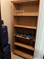Wooden bookshelf standing empty with five shelves for storage or display. Measurements roughly 35x12x75 inches.