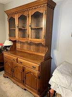 Full view of two-piece Roxton china cabinet from the side angle showing wooden brown finish and detailing.