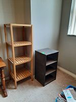 Photo of both shelving units side by side in a room corner, showing the height and shelf design differences.