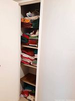 Shelves filled with folded towels and mats in various colors and sizes.