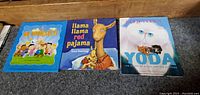 Front covers of the three hardcover books laid side by side on carpet.