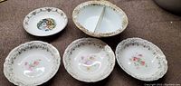 Top view of five vintage bowls showing floral and ornate designs.