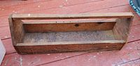 Top view of elongated wooden toolbox showing internal compartment and handle