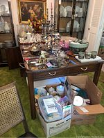 Front view of accordion table showing top surface, cabinet base and items on top.