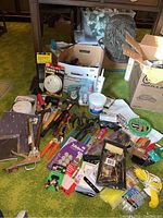 Overview photo showing a variety of home care tools including hand tools, smoke alarms, and painting supplies arranged on the floor.