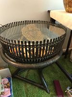 Front angle showing wicker base and coral with shells inside table under glass top
