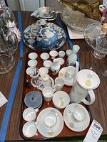 Wide view of the entire tea set, sake cups, and decorative items laid out on a table.