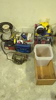 Full lot wide view showing Wagner power painter, battery boosters, plastic and wood boxes, and spools of wire and beaded chain