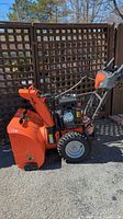 Side profile of snowblower showing auger housing and frame