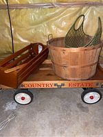 Photo showing the Country Estate wooden wagon with removable wood rails, large wood bushel basket, green snowshoes inside the basket, and the stained glass racket nearby.