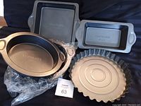 Five baking pans arranged together: round, square, loaf, and fluted edge pans, showing sizes and shapes.