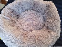 Top view of soft, fluffy taupe donut dog bed showing plush texture and round shape.