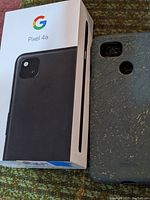 Google Pixel 4a original retail box with black phone image and protective case beside it.