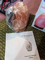Mini Himalayan salt lamp crystal with USB cable and instruction manual showing the product image.