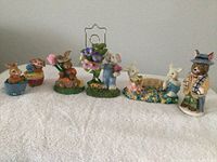 Seven rabbit and Easter themed figurines displayed together on a white textured background.