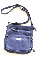 Front view of blue Roots crossbody handbag showing main flap and zipper pocket.