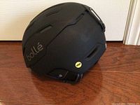 Side view of matte black Bolle ski helmet showing vents, branding, and MIPS sticker.