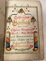 Close-up of title page with colorful floral decorations and calligraphy in German titled "Gebetbuch" (prayer book).