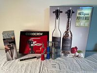 Overview of all items including Kuraidori wine decanter aerator, Mr. Thompson salt and pepper mill set, various corkscrews including mini red and blue, and traditional corkscrew.