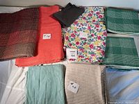 Initial overview of various folded fabrics including floral, solid, striped, and checkered patterns.