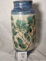 Front view showing relief tree branch decoration in green and blue on cream background