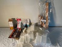 Lot of cleaning items including bottle cleaning beads, brushes with wooden handles, and silicone scraper tool.