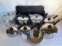 Overview of all cookware pieces including pots with lids, frying pan, mixing bowl and griddle pan