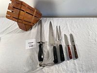 Shot showing the complete set including wooden knife block, carving knife, paring knives, and two-pronged fork.