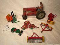 Overall view of the full set of vintage metal toy vehicles and implements on white background