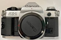 Top view of Canon AE-1 Program silver and black 35mm film camera body with lens mount cap attached