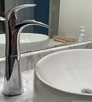 Delta Nyla single handle riser faucet installed on a vessel sink, chrome finish visible