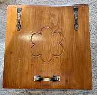Top view of pine box showing carved clover design, metal hinges, and handle.