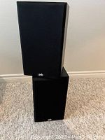 Two PSB 300 stereo speakers stacked vertically, front view with grilles on.