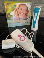 BellaFace skin rejuvenator device, Braun Silk-epil 7 epilator, and adaptors shown together with BellaFace box.