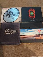 Four Pearl Jam albums displayed together showing front covers: Binaural, Rearviewmirror, Vitalogy, and Yield.