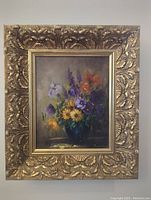 Front view of painting in ornate gold frame showing floral still life
