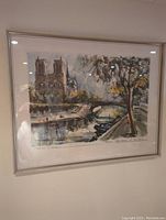 Full frontal image of the framed watercolor painting showing Notre Dame Cathedral with river, bridge, trees, and soft artistic brushwork.
