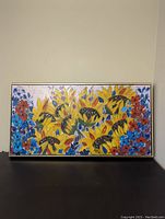 Full view of framed colorful oil painting depicting sunflowers and other flowers.