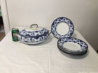 Photo showing the tureen with lid and seven matching bowls stacked alongside a soda can for size reference