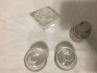 Top view showing square glass inkwell, two round inkwells, and small vintage jar.