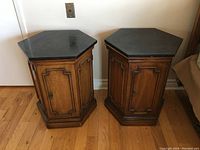 Pair of hexagon-shaped nightstands with black marble tops side by side.