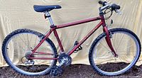 Side view of Gary Fisher Tassajara maroon mountain bike with knobby tires showing frame, saddle, drive train components.