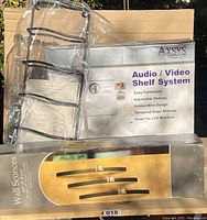 Photo showing wine rack, Axys audio/video shelf system box, and box for black steel wall sconces