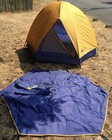 Complete dome tent set up outdoors showing yellow rainfly and blue-grey inner tent with door open