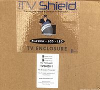 Close-up of the shipping box label displaying the brand 'The TV Shield' and specifying the enclosure model TVS4050-1 for screens 40 to 50 inches.